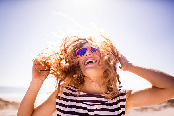 joyeux rire femme sur la plage - blue water flash photos et images de collection