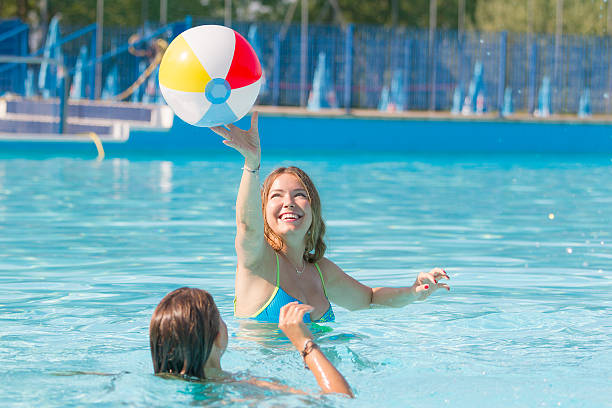 istock Two young women playing with ball on swimming pool 483204722