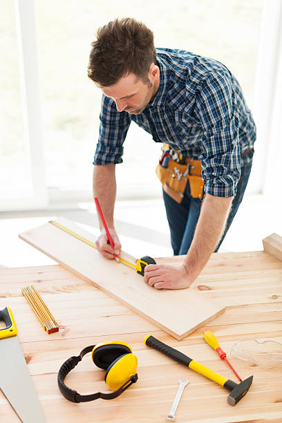 istock Carpenter checking dimensions of wooden plank 483204731