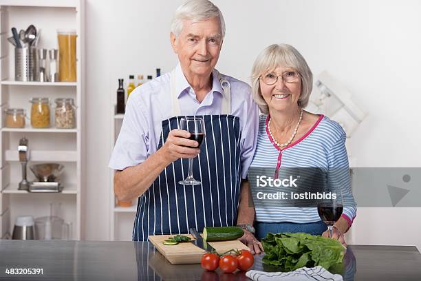 Photo libre de droit de Couple Senior En Prenant Une Pause De Préparer Une Salade banque d'images et plus d'images libres de droit de Adulte