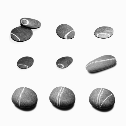 a set of gray pebbles with white stripes on white background.