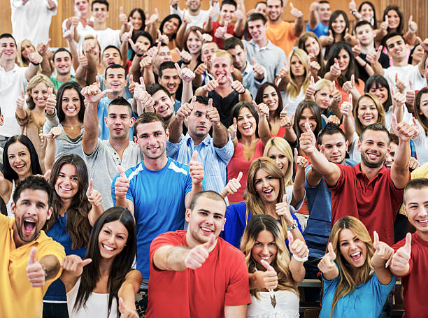 large group of cheerful students, показывая пальцем вверх. - thumbs up teenager adolescence group of people стоковые фото и изображения