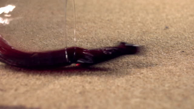 Slow motion red wine spilling on carpet