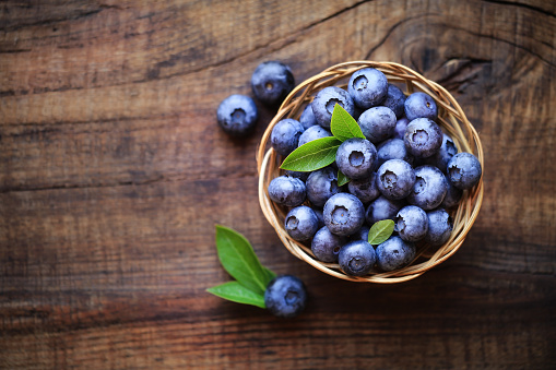 Moist blueberries background with green leaves