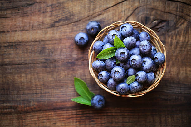 Fresh blueberries Fresh ripe garden blueberries in a wicker bowl on dark rustic wooden table. with copy space for your text blueberry photos stock pictures, royalty-free photos & images