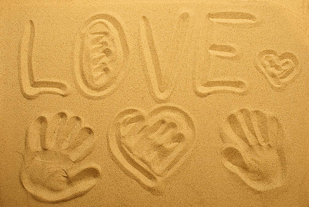 istock inscription love on the sand. Top view. 483214688