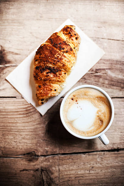 istock Croissants with coffee on wooden background 483214722