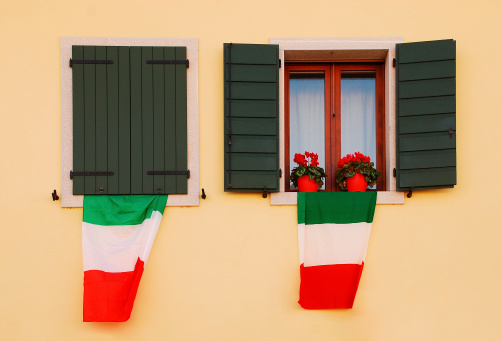 Italian flags - Il Tricolore - hang out of the windows of an old rural village building.