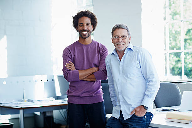 business colleagues in bright office - standing smiling two people 30s 뉴스 사진 이미지