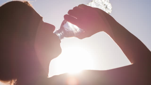 Young woman hydrating after high intensity workout