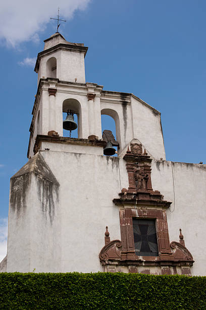 istock White church bell tower against blue sky 483253056