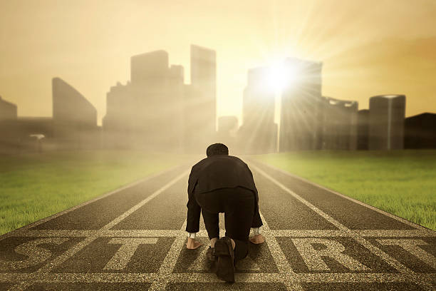Worker prepare to compete on the start line Businessman wearing formal suit and kneeling on the start line to prepare the competition runner on start pose stock pictures, royalty-free photos & images