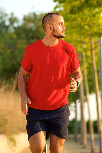 istock Young man running with earphones outside 483258550