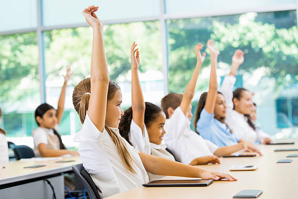 escola primária de alunos levantar as mãos para a resposta para o professor pergunta - schoolboy relaxation happiness confidence imagens e fotografias de stock