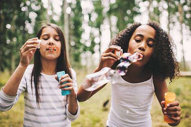 istock Cute girls blowing bubbles outdoors 483259199