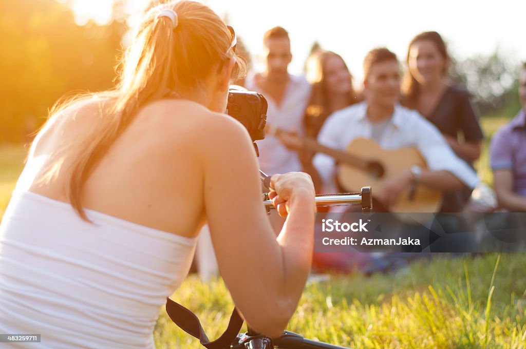 Videographer shooting teenagers Videographer shooting teenagers at picnic. Teenager Stock Photo
