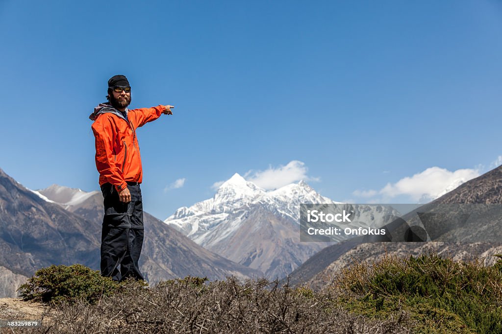 Man Hiker on Mountain Summit Pointing a Direction Man hiker, Annapurna trek, Nepal Achievement Stock Photo