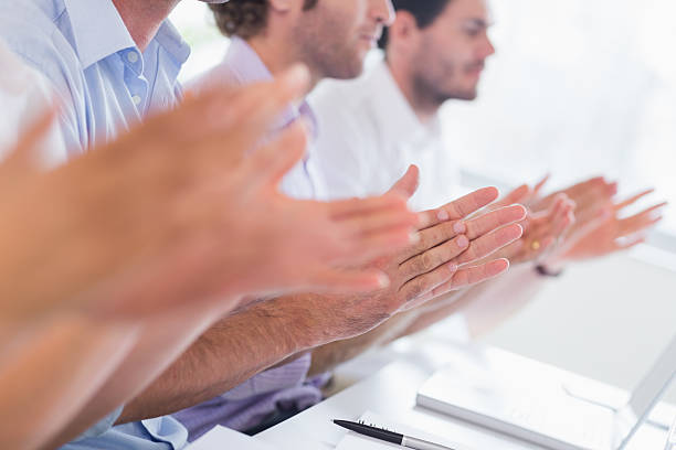 istock Mid section of executives clapping hands at desk 483260535