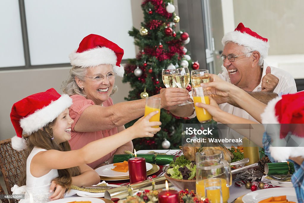 Hijos y abuelos brindis jugos durante Navidad - Foto de stock de Familia libre de derechos