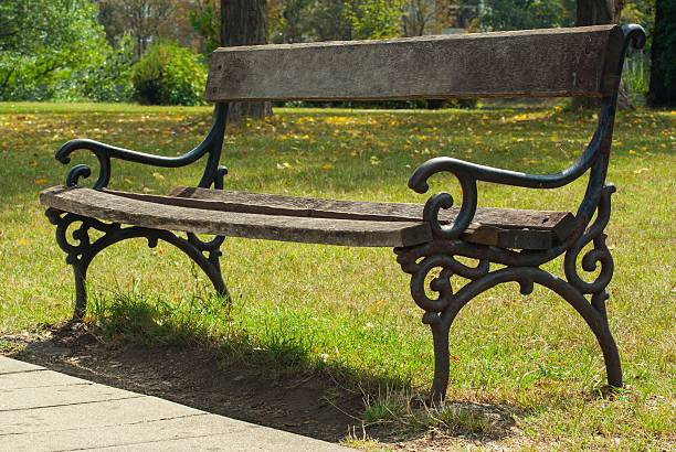 istock Bench in park with green grass and woods 483263514