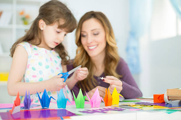istock Mother and daughter making origami. 483265191