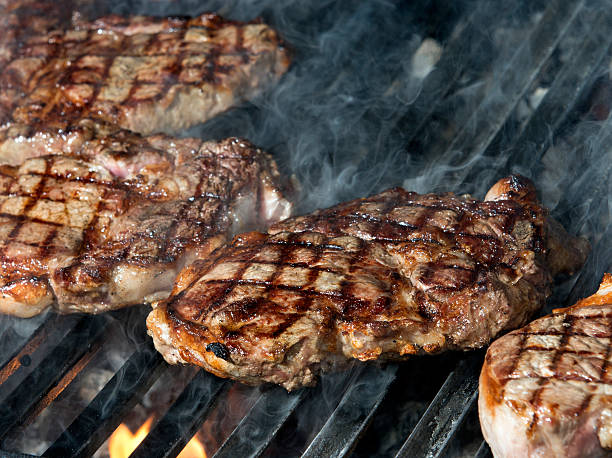 istock beef steak cooking on an open flame grill 483265881