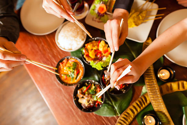 joven comiendo en el restaurante thai thai - asian cuisine fotografías e imágenes de stock