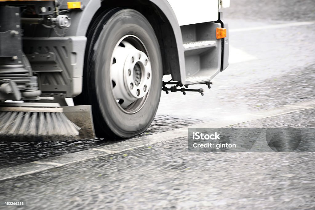 Street cleaning vehicle A road sweeping vehicle adjusted a sidewalk with cobblestones of dirt. Street Sweeper Stock Photo