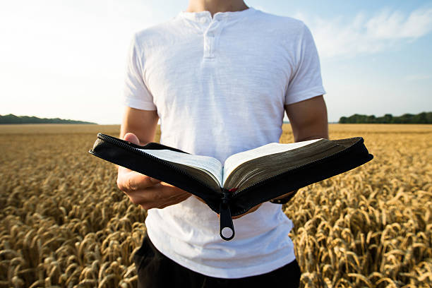 istock Man holding open Bible in a wheat field 483266988