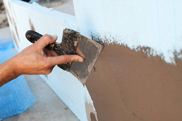 istock Man hand with trowel plastering a wall 483275726