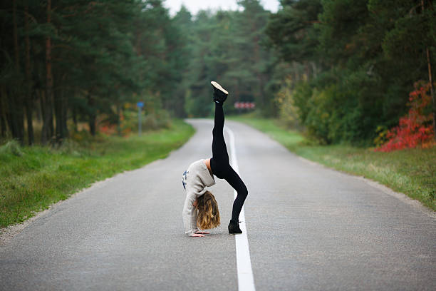 istock Young girl makes splits on the highway 483276870