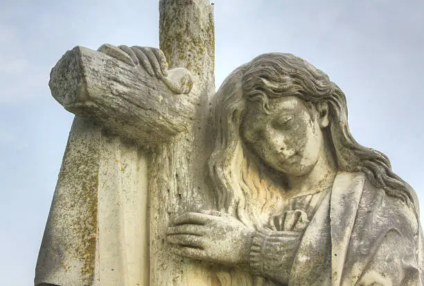 A close up photograph of a very old cemetery statue.