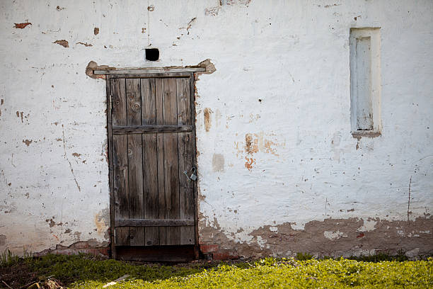 istock old house white wall with wooden door 483280368