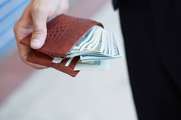 istock man holding a purse with money closeup 483285324