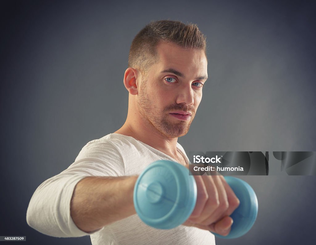 Handsome man holding dumb bells Happy attractive sporty handsome man doing workouts Activity Stock Photo