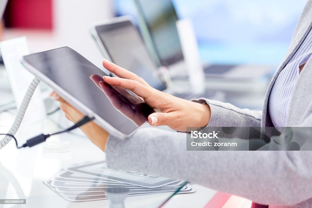 Buying digital tablet Unrecognizable person looking shopping for digital tablet in electronics store Buying Stock Photo