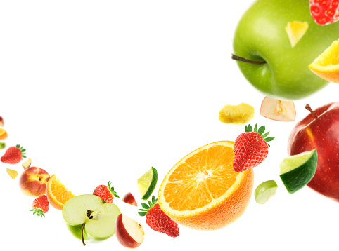 There is a close up of fruits to the right of the screen, including apples, strawberries, oranges and limes.  The fruits are floating in the air, and they are tapering off down and into the background to the left.  The background is stark white.