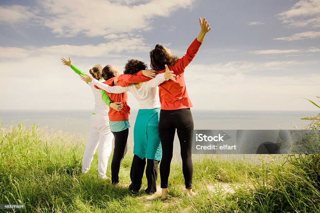 Cuatro de edad intermedia mujeres los brazos abiertos al aire libre - Foto de stock de 40-49 años libre de derechos