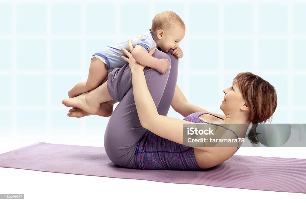 Yoga Mother with her baby boy doing yoga exercise. 12-17 Months Stock Photo