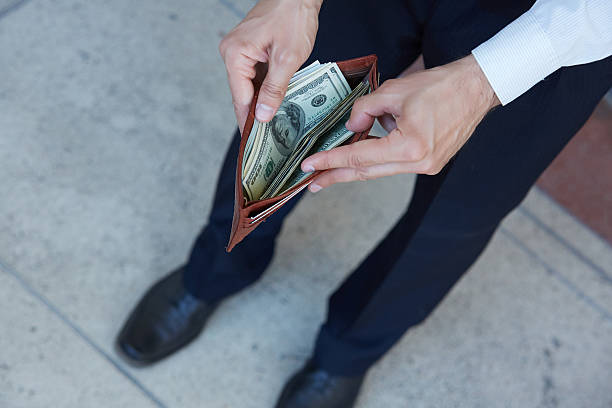 istock man holding a purse with money closeup 483292554