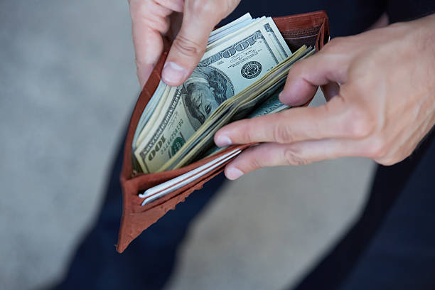 istock man holding a purse with money closeup 483292556