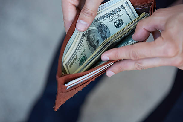 istock man holding a purse with money closeup 483292558