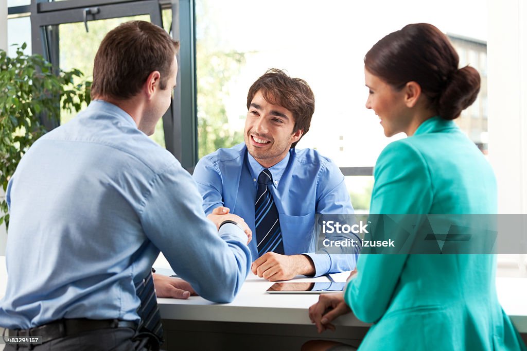 Business meeting Adult couple having meeting with business consultant. Men shaking hands. Honesty Stock Photo