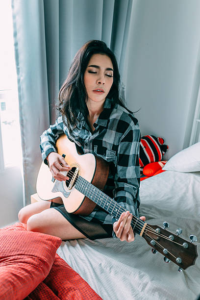 istock asia women playing guitar 483296186