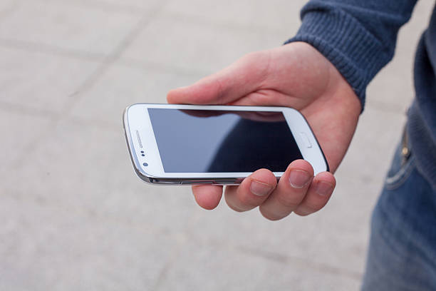 istock Close up of a man using mobile smart phone outdoor. 483301114