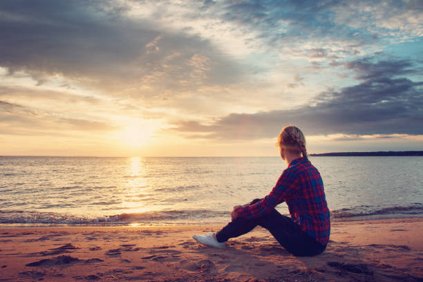 istock young woman looking at sunset 483304112