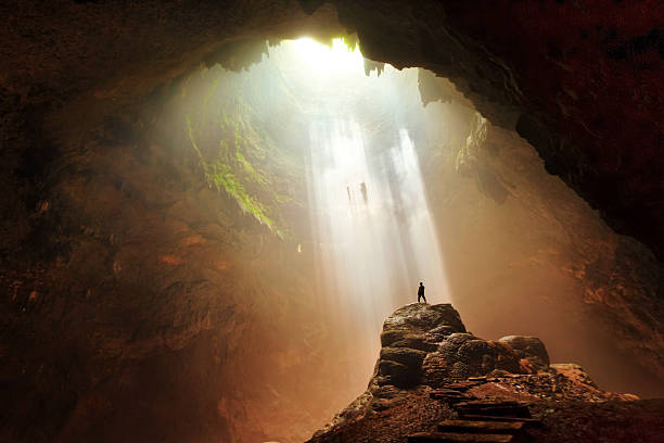 Man Standing on rock underground cave light yogyakarta indonesia
