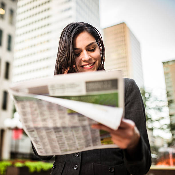 negócios mulher a ler o jornal e ligar para telefone - reading newspaper 30s adult imagens e fotografias de stock