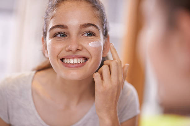 Fostering healthy skincare habits Shot of a teenager applying moisturizer to her face in front of the mirrorhttp://195.154.178.81/DATA/i_collage/pu/shoots/805371.jpg good condition stock pictures, royalty-free photos & images