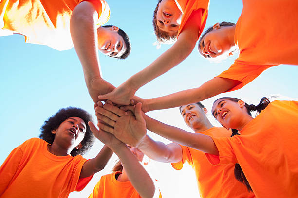 entrenador con grupo de niños - hands in the middle fotografías e imágenes de stock